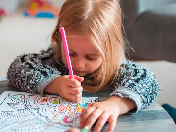 Family colouring books in their living room. They are having fun together.