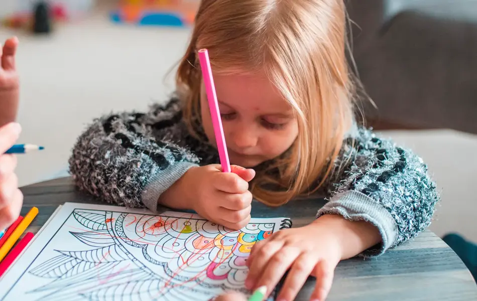 Family colouring books in their living room. They are having fun together.