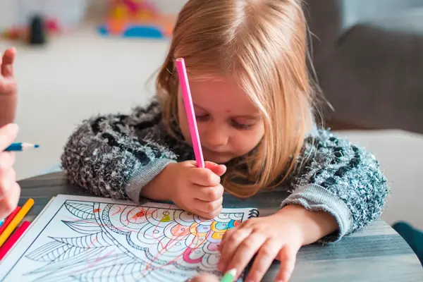 Family colouring books in their living room. They are having fun together.