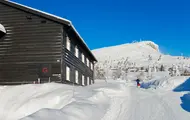 Bilde som viser boligprosjektet Skitorget på Skeikampen. Blå himmel, sol og masse flott hvit snø.