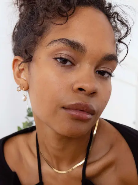 modell med øredobber og gullkjede