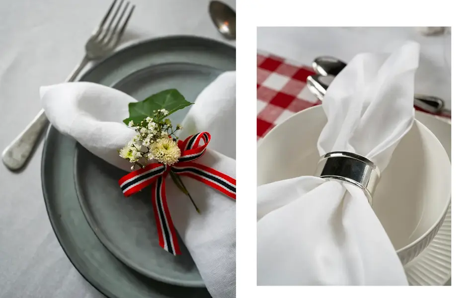 Nærbilde av hvit linserviett med bånd og blomster på en grå tallerken. Hvit linserviett med sølvfarget serveiettring på hvit skål.