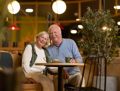 Eldre par, mann og dame, som sitter på cafe. 