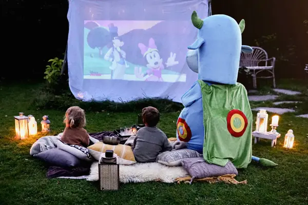 oskar og barna har utekino i hagen