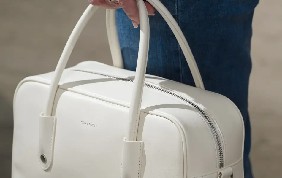 hånd holder hvit veske