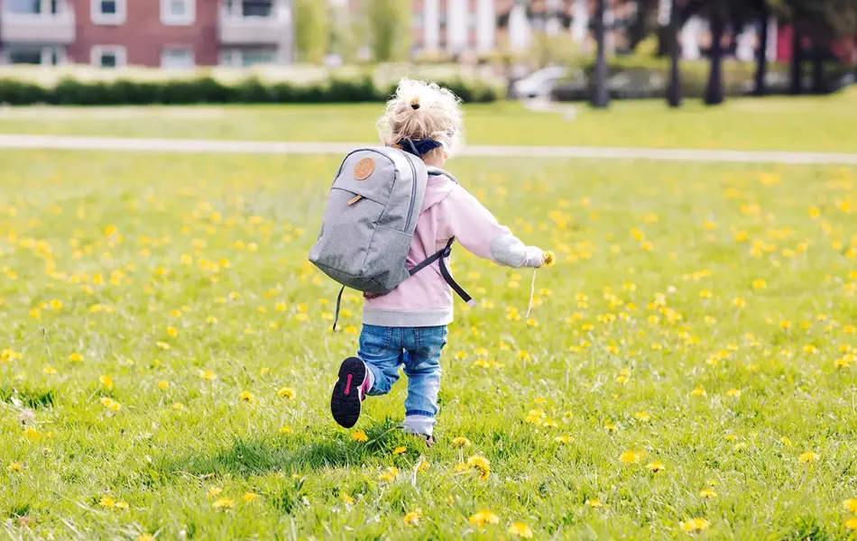 Bilde av barn med ryggsekk på gressplen