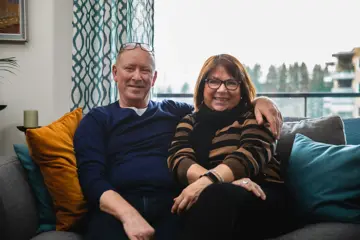 Et voksent par som sitter i en sofa