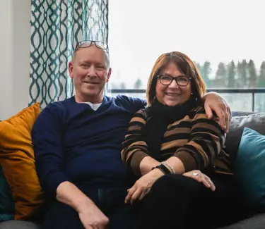Et voksent par som sitter i en sofa