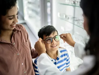 Gutt som får briller tilpasset av en optiker