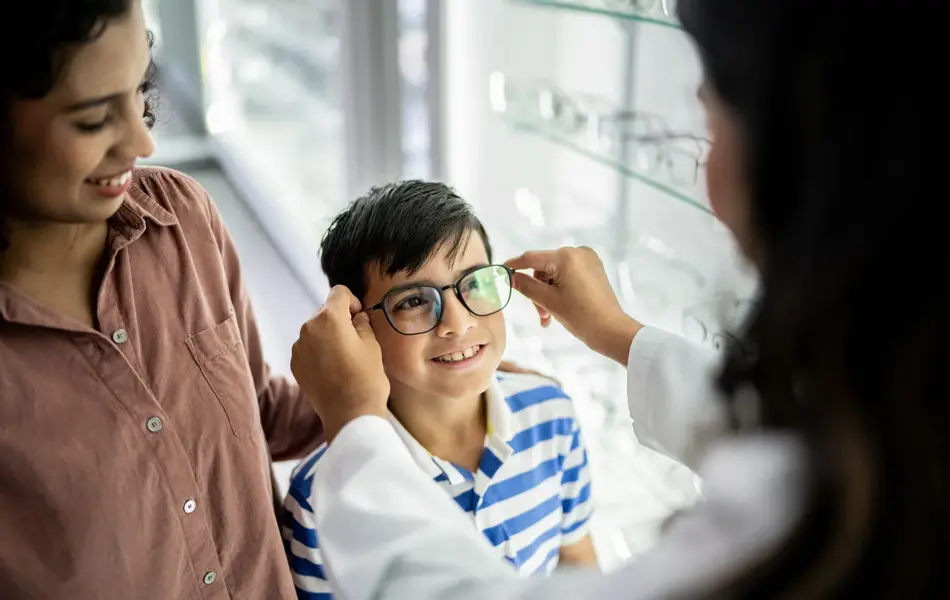 Gutt som får briller tilpasset av en optiker