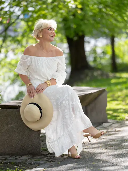 Dame i hvit lang kjole, stråhatt og sandaler