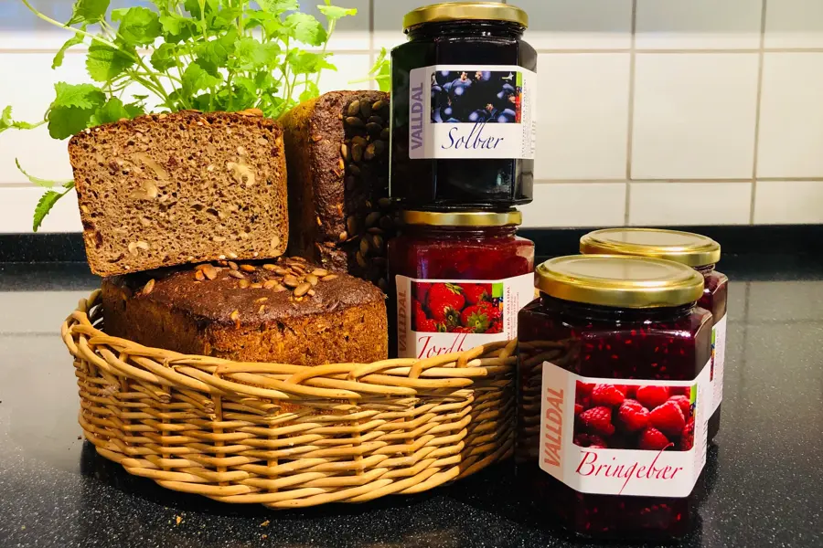 Kurv med brød står ved siden av syltetøy