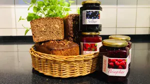 Kurv med brød står ved siden av syltetøy
