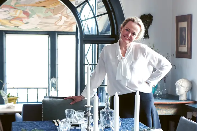 kvinne som lener seg til stol ved spisebord