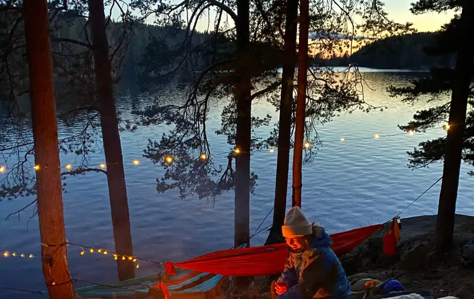 Venner på tur i skogen med bål og lyslenker i mørket