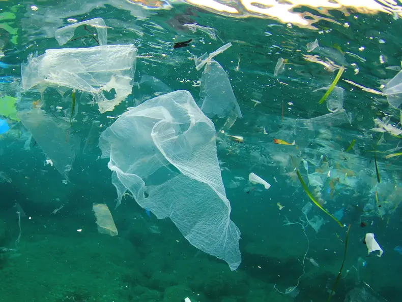 Et bilde under vann av masse søppel og plast.