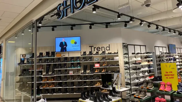 innendørs butikk med sko og reoler og skilt