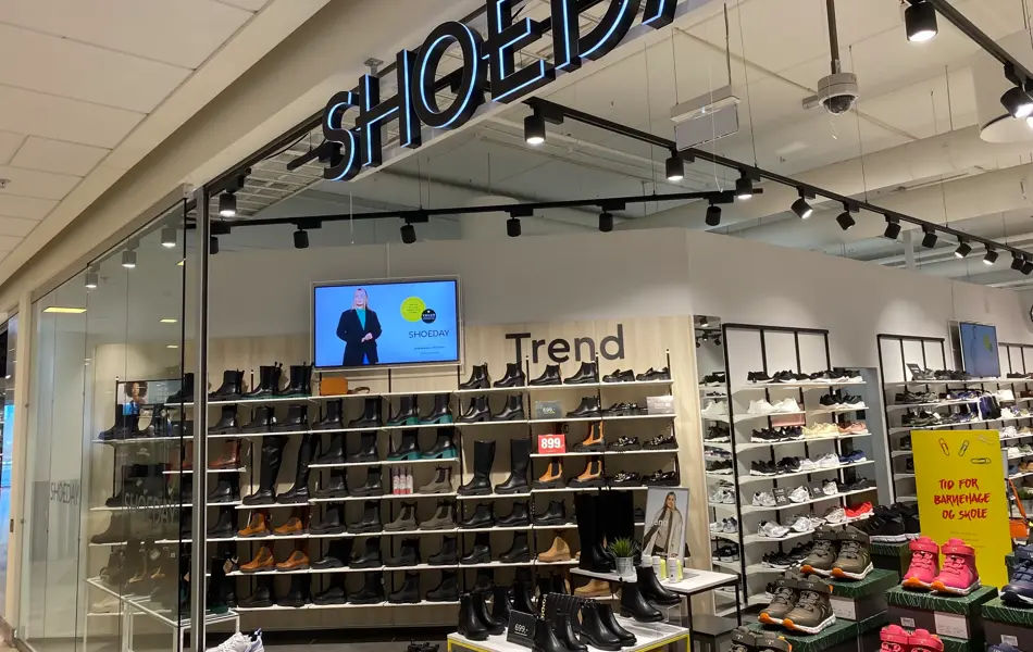 innendørs butikk med sko og reoler og skilt