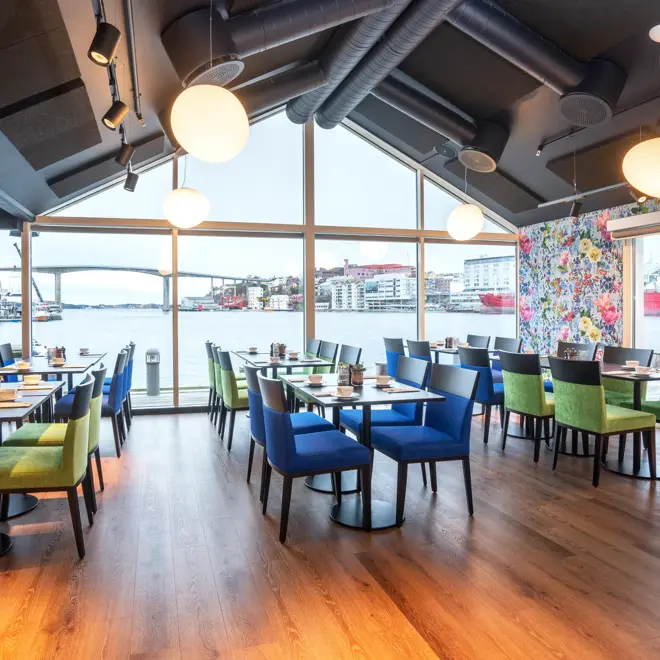 Restaurant, vindu, utsikt mot vannet, grønne og blå stoler, spisebord, parkettgulv, blomstertapet