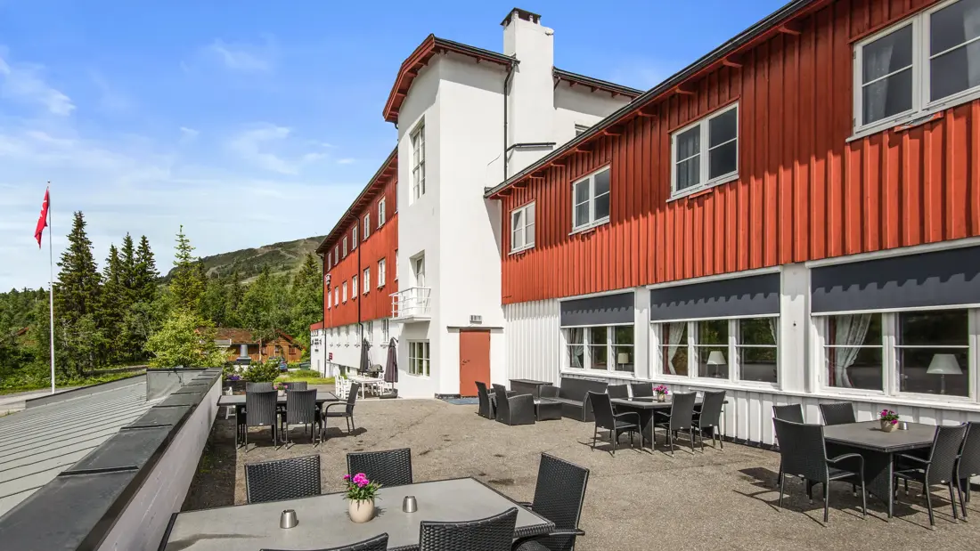 Fasade med terrasse og sitteplasser på sommertid på Thon Hotel Skeikampen