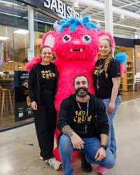 Bildet viser noen ansatte på kjøpesenteret Kvadrat i Sandnes. 3 ansatte står sammen med den rosa maskotten på sentret