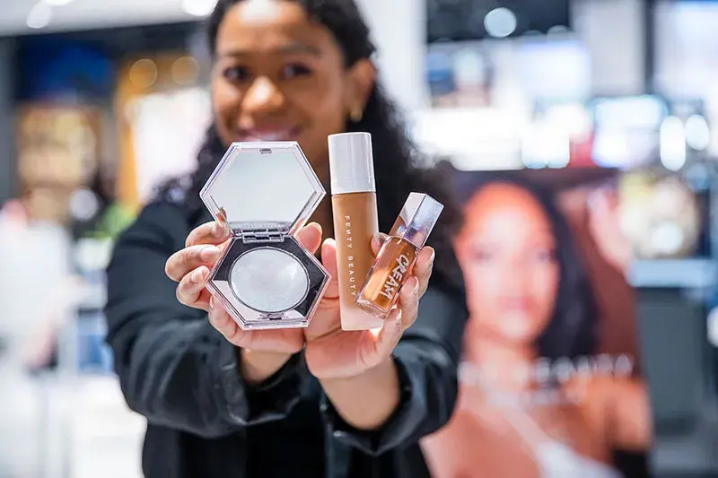 Bilde av butikkansatt som viser frem makeup