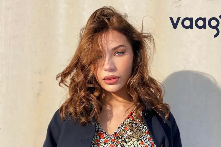 Dame med blomstrete kjole og blå blazer. Tekst: Vaag