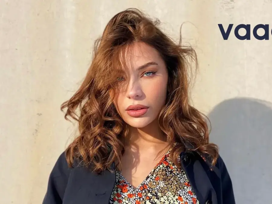 Dame med blomstrete kjole og blå blazer. Tekst: Vaag