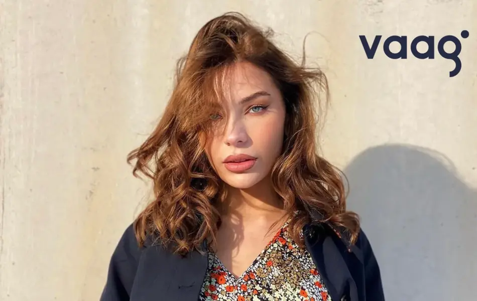 Dame med blomstrete kjole og blå blazer. Tekst: Vaag