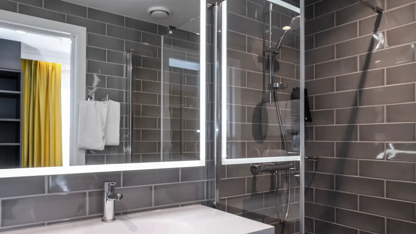 Grå veggfliser, vask, dusj
