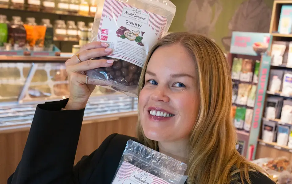 Dame holder tre poser nøtteblandinger fra Nøtteblanderen