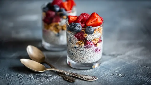 Healthy vanilla chia pudding in glass with fresh berries on vintage concrete table. Copy space. Banner.