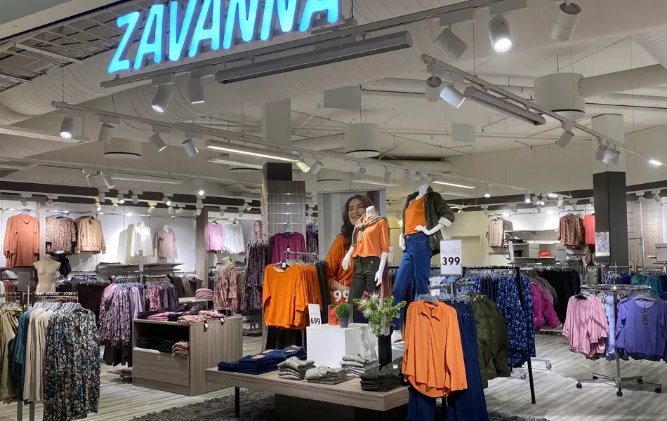 innendørs butikk med klær for dame og dukker og hvite skilt