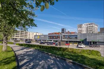 Fasadebilde av AMFI Vågsbyd som ligger langs en gangsti med grøntområde, i pent sommervær