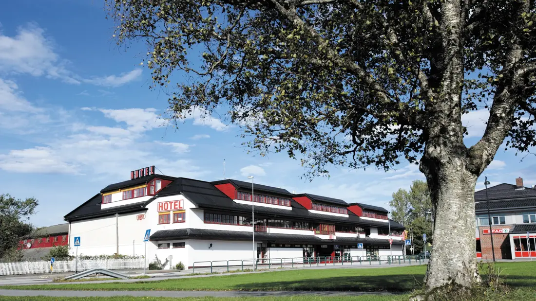 Fasadebilde av hotellet på sommeren, med grønt gress og blå himmel  på Thon Hotel Baronen rett ved Ålesund