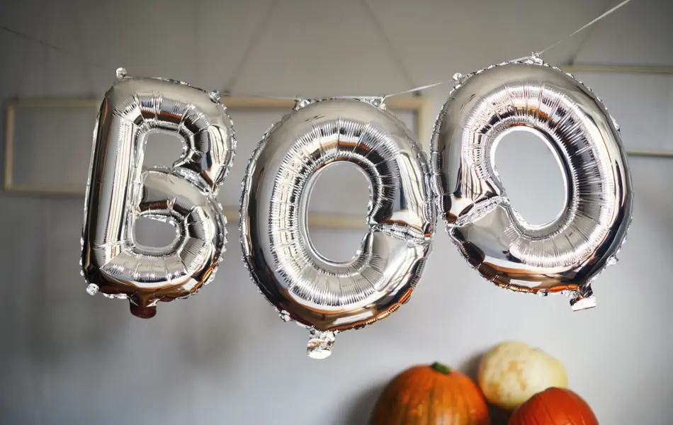 Silver balloons that spell the word 'boo'