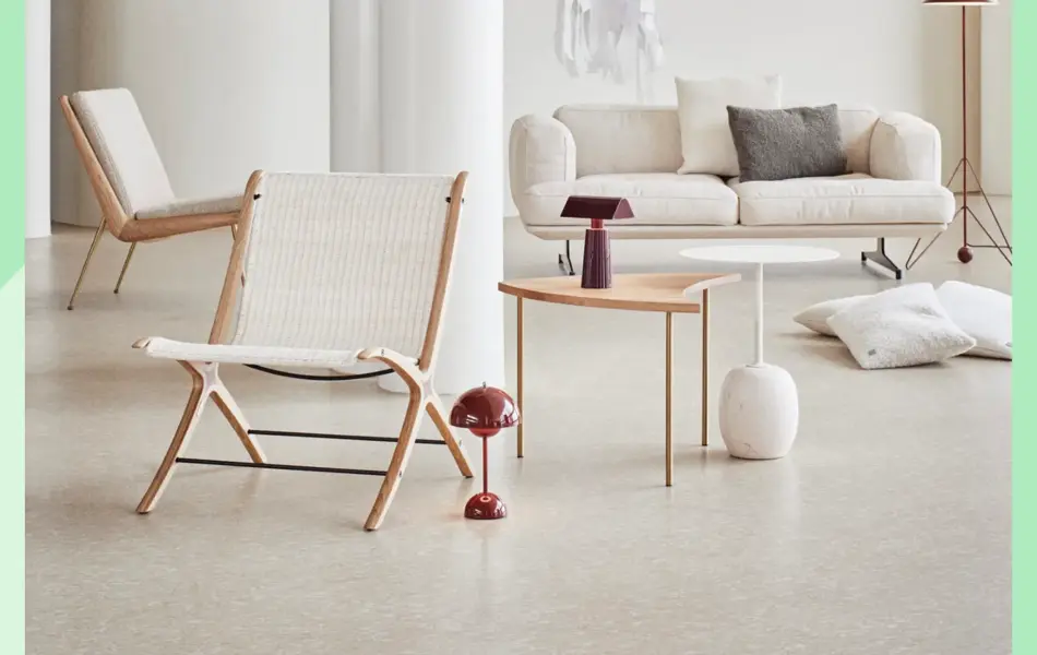 Stort rom med hvit sofa, to hvite stoler, lite sofabord, lamper og puter.