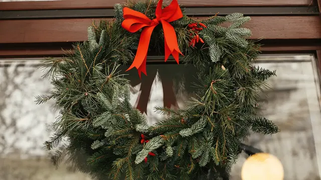 Julekrans med sløyfe henger på døra