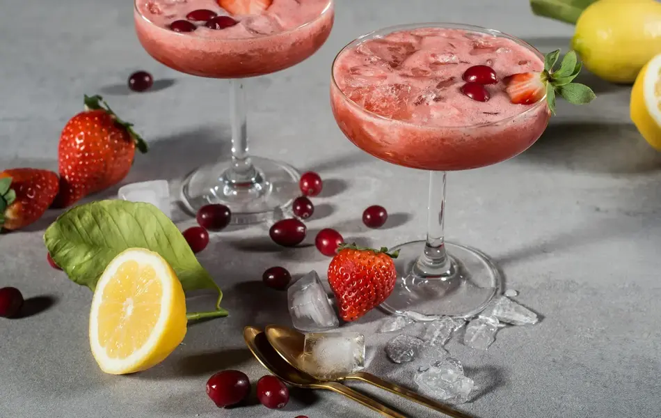 To cotcktailglass med rød drink i