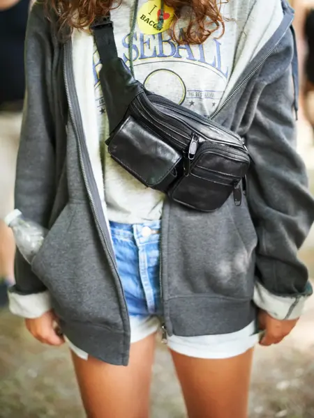 Cropped image of a young woman wearing a moon bag around her shoulders