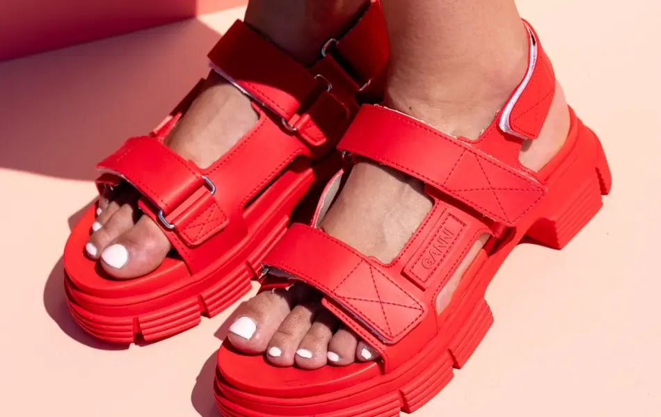 Rrøde stroppesandaler med borrelås på en damefot
