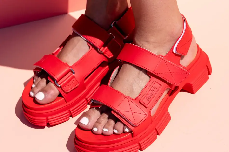 Rrøde stroppesandaler med borrelås på en damefot