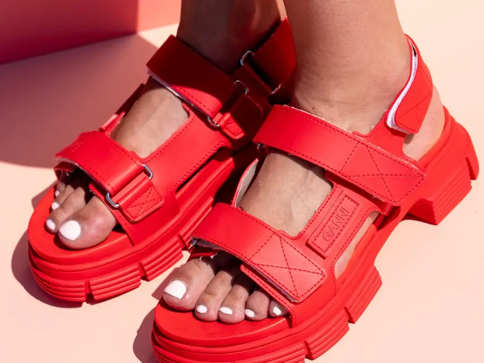Rrøde stroppesandaler med borrelås på en damefot