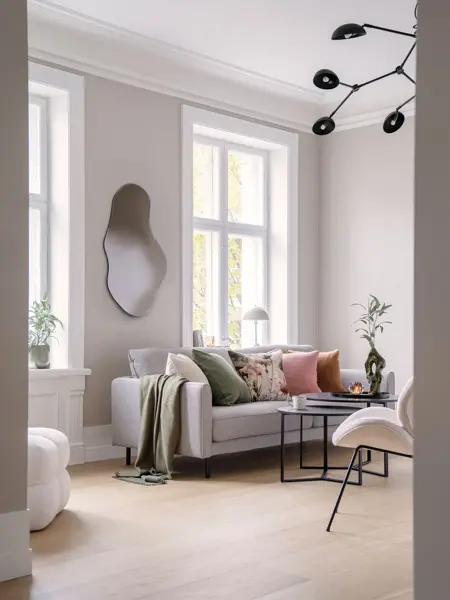 Stue med sofa, bord, stol og speil på veggen