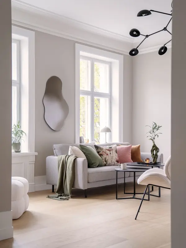 Stue med sofa, bord, stol og speil på veggen