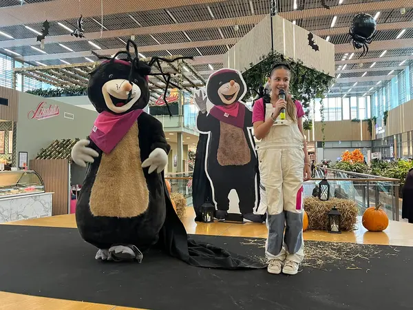Maskoten Mirre Mullvad och Mira dansar på scen i Mirum Galleria