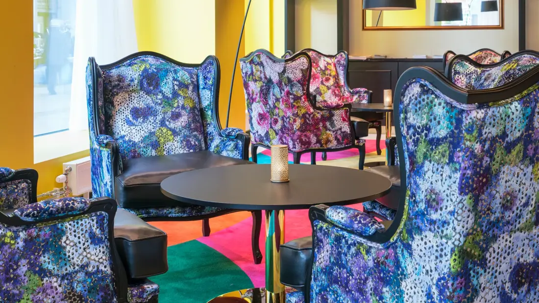Lobby med fargerikt teppe og blomstermønstrede stoler på Thon Hotel Spectrum i Oslo sentrum