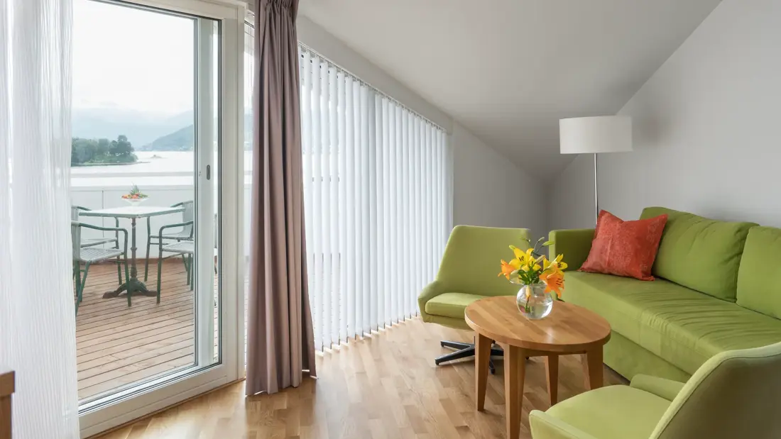 Toroms leilighet med sofa og verandadør ut mot veranda på Thon Hotel Sandven i Nordheimsund