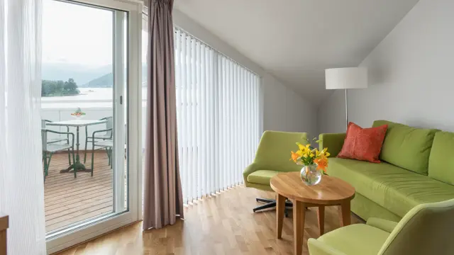 Toroms leilighet med sofa og verandadør ut mot veranda på Thon Hotel Sandven i Nordheimsund