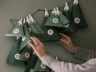 Dame henger opp julekalender på veggen